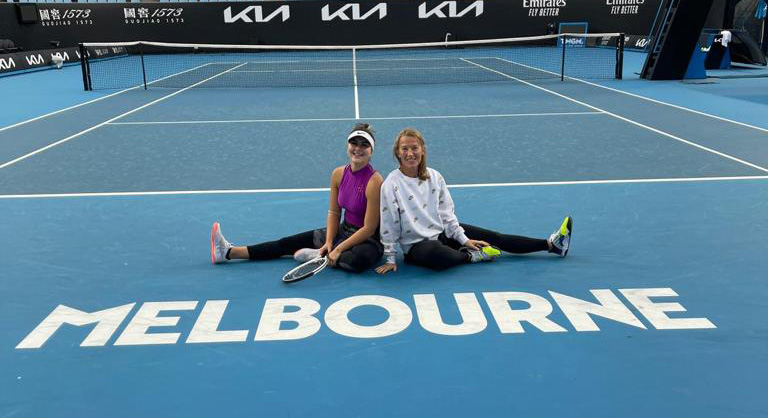 Bianca Andreescu and Kirstin Bauer sit together on the tennis court in Melbourne